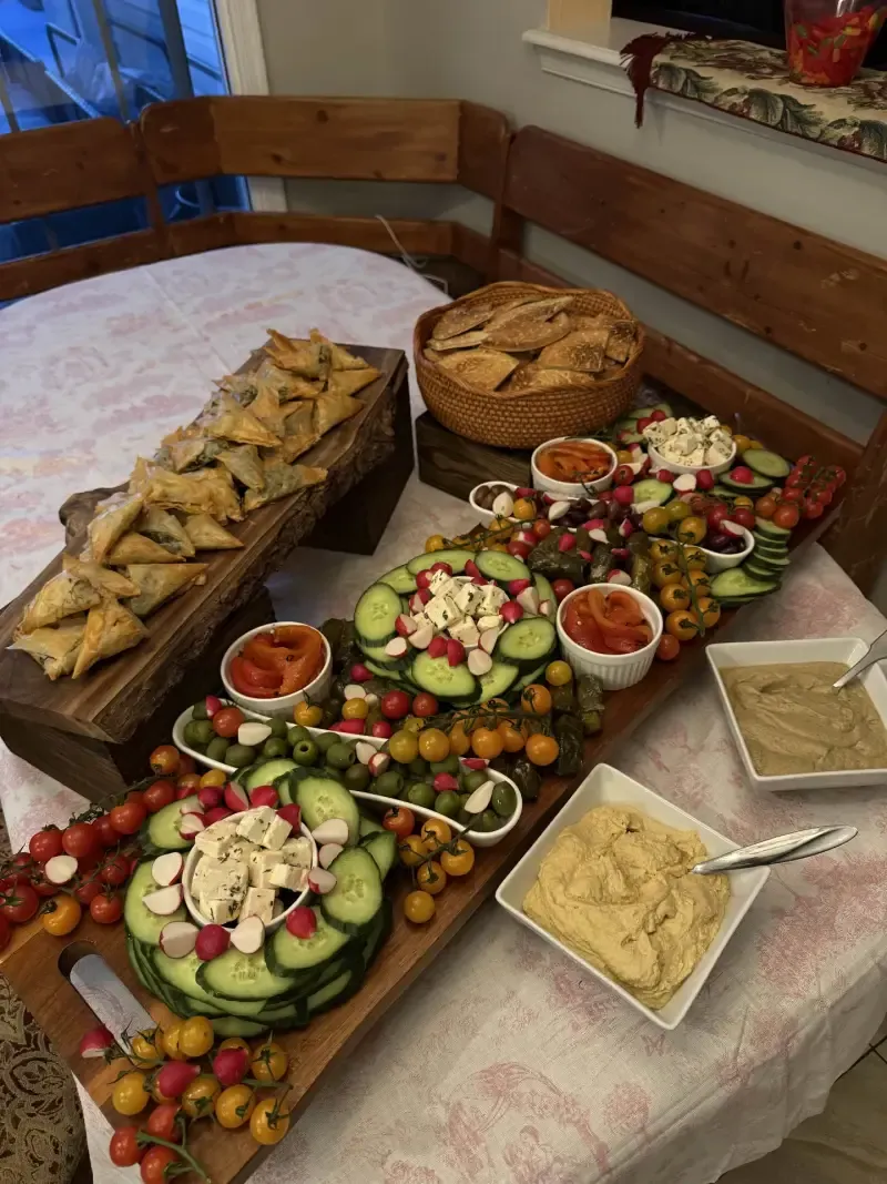 Greek mezze spread with spanakopita, hummus, and fresh vegetables by Chef Matt